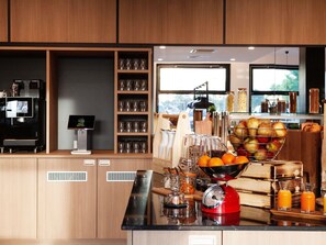 Una cocina con cafetera, frutero y extractor de zumo.