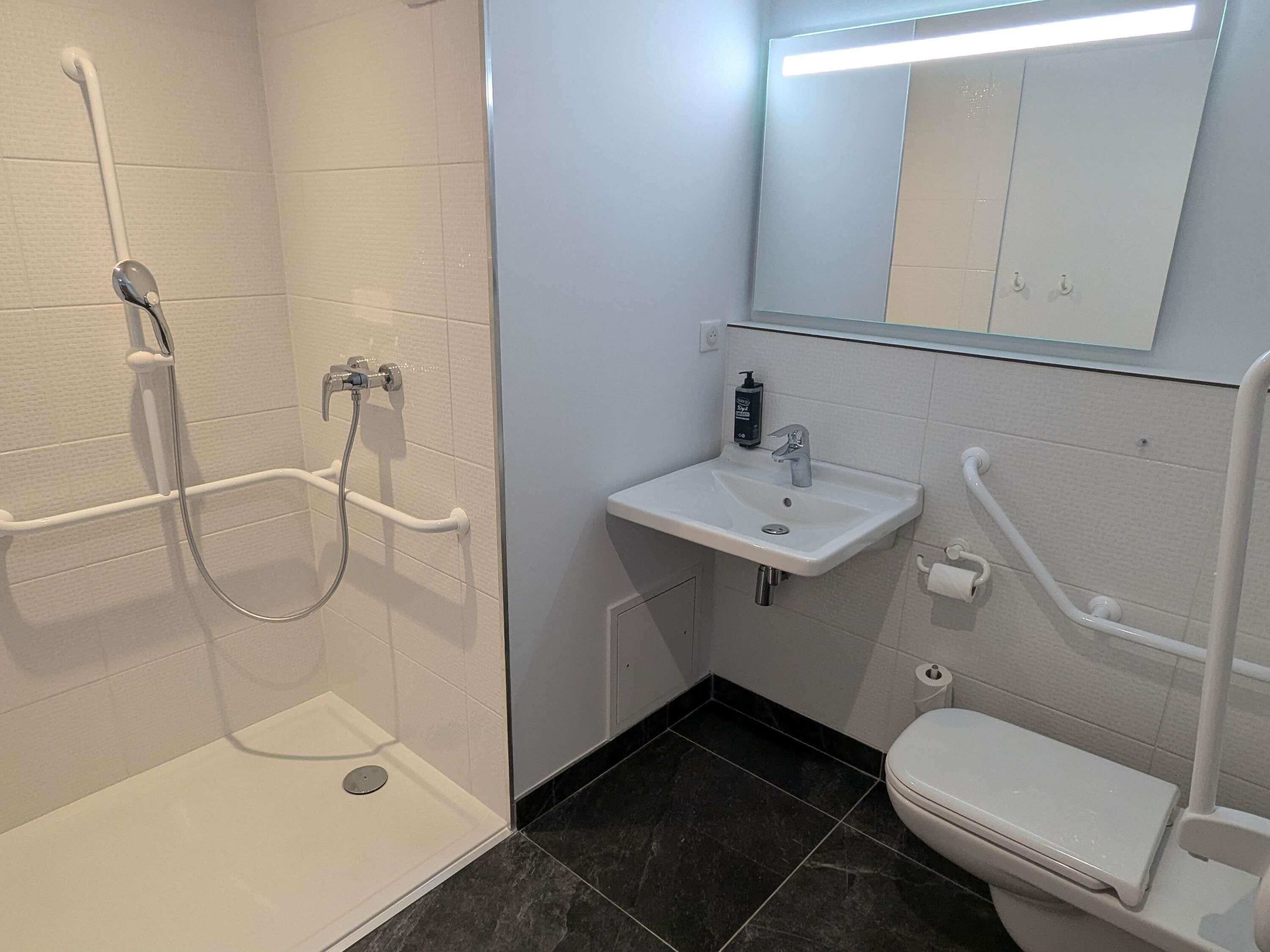 Un baño con ducha, lavamanos e inodoro.