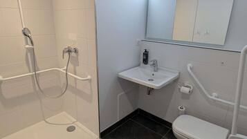 Un baño con ducha, lavamanos e inodoro.