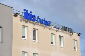 A hotel named "Ibis Budget" with a beige facade and multiple windows. - Ibis Budget Noyon (Noyon)