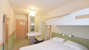 A compact hotel room with bunk beds, a small bathroom, and a walk-in closet. - Ibis Budget Noyon (Noyon)