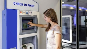 Una mujer usando un punto de registro con logotipos de Visa y Mastercard.