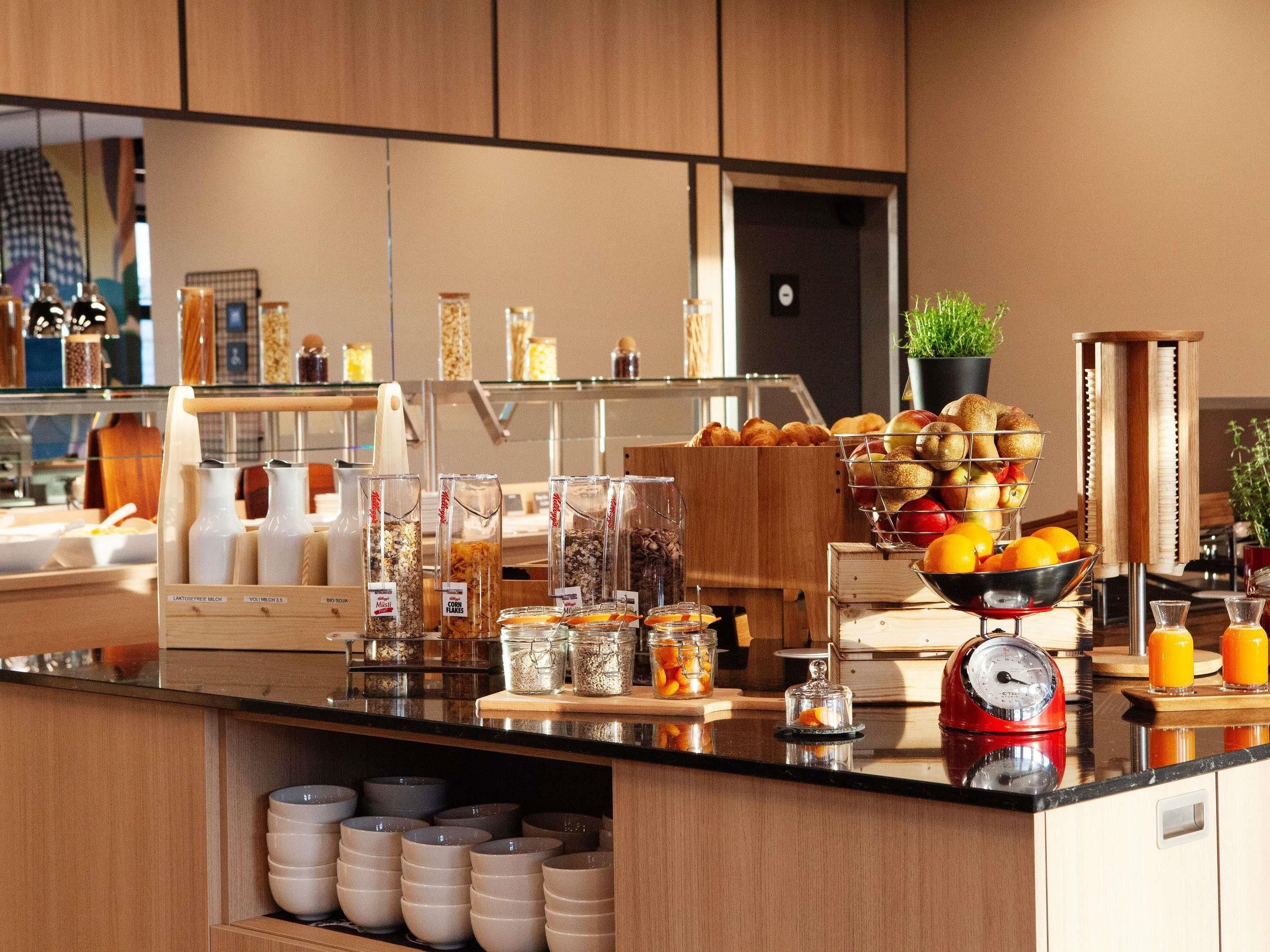 A breakfast buffet with various food items, a coffee machine, and a scale.