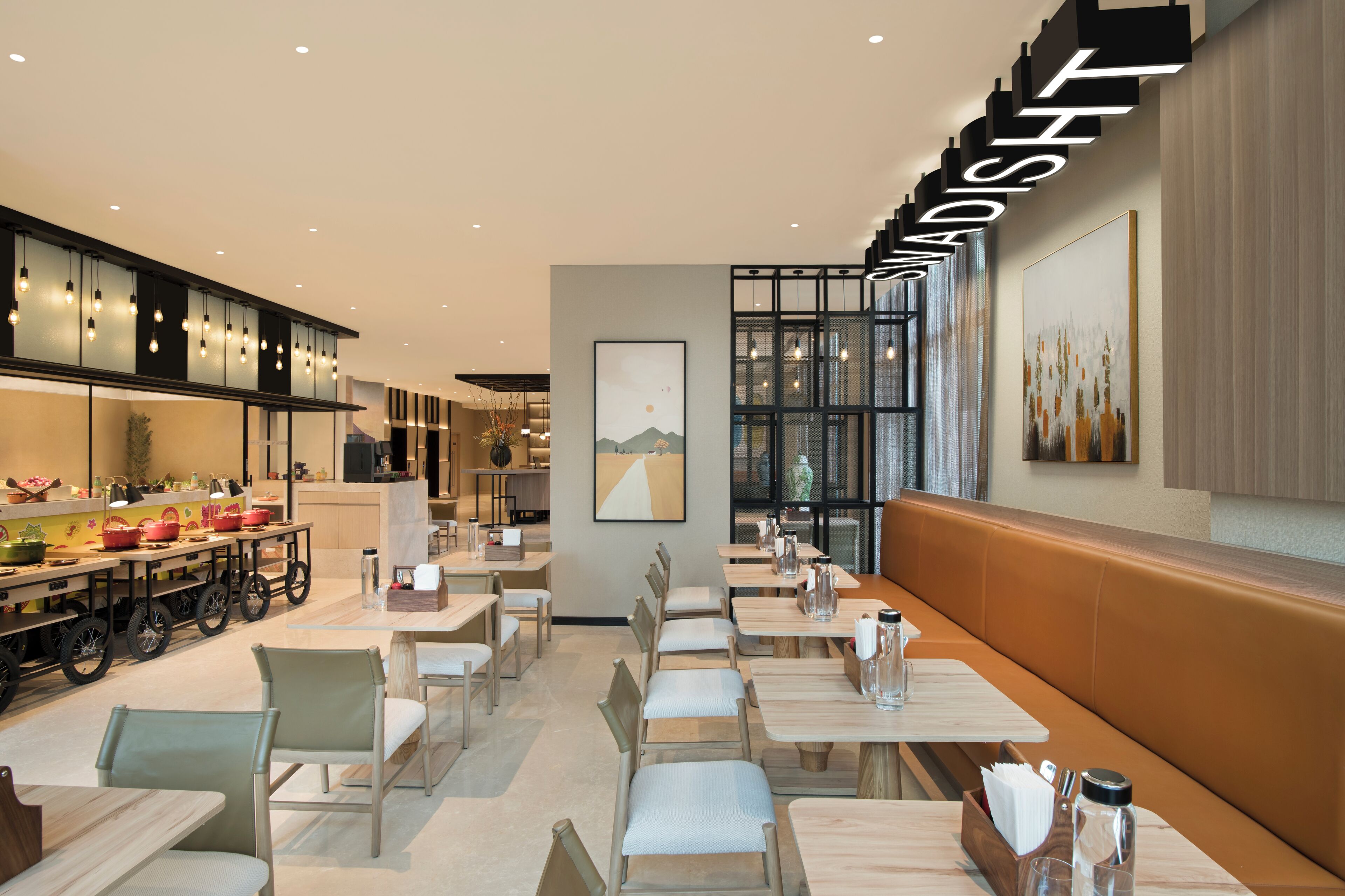 A modern restaurant with a long counter, booths, and a high ceiling with recessed lighting.