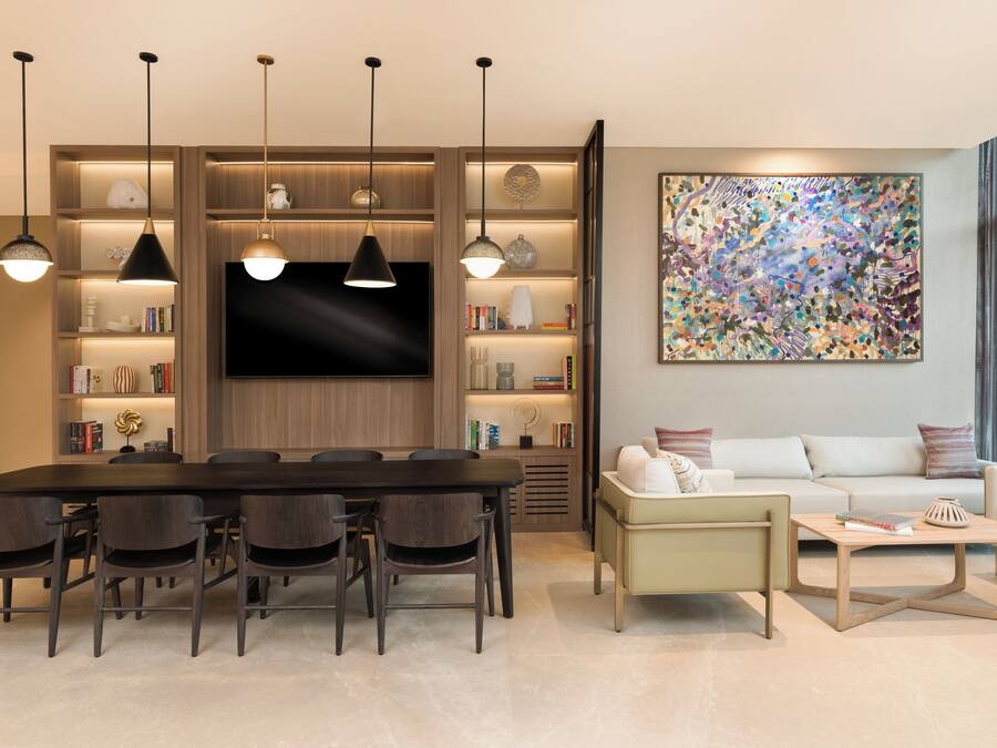 Una sala de estar moderna con comedor, televisor de pantalla plana y un cuadro abstracto grande.