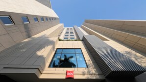 A modern building with a prominent 'ibis' sign, large windows, and a geometric design. - Ibis Mumbai Bkc (Mumbai)
