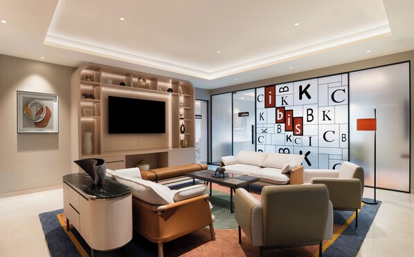 A modern living room with a flat-screen TV, a sofa set, and a coffee table. - Ibis Mumbai Bkc (Mumbai)