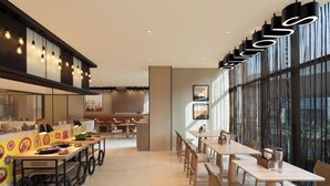 A modern restaurant with a long counter, multiple tables, and a large window with curtains. - Ibis Mumbai Bkc (Mumbai)