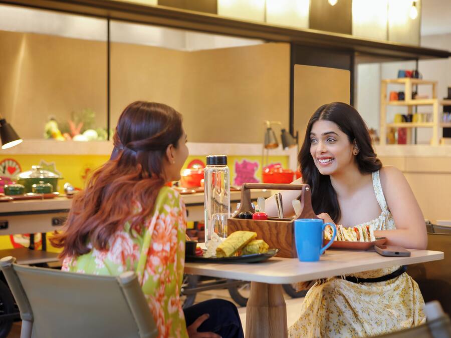 A dining area with a table, chairs, and a counter with kitchen items.