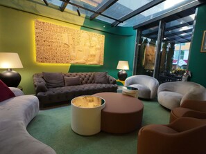 A modern living room with a green wall, a large text mural, and a glass ceiling. - Ibis Styles Ankara (Ankara)