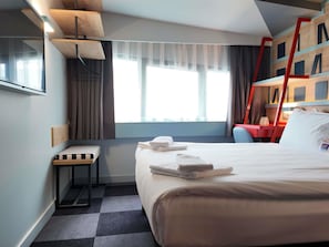 A hotel room with a bed, a desk, a chair, a window with curtains, and a red ladder against the wall. - Ibis Styles Ankara (Ankara)