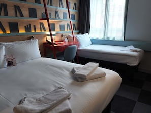 A hotel room with two beds, a desk, and a window with curtains. - Ibis Styles Ankara (Ankara)
