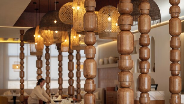 Interior de restaurante con decoración de madera y lámparas colgantes.