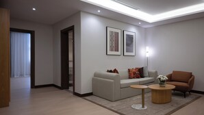 Una sala de estar moderna con un sofá, dos mesitas auxiliares y una lámpara.