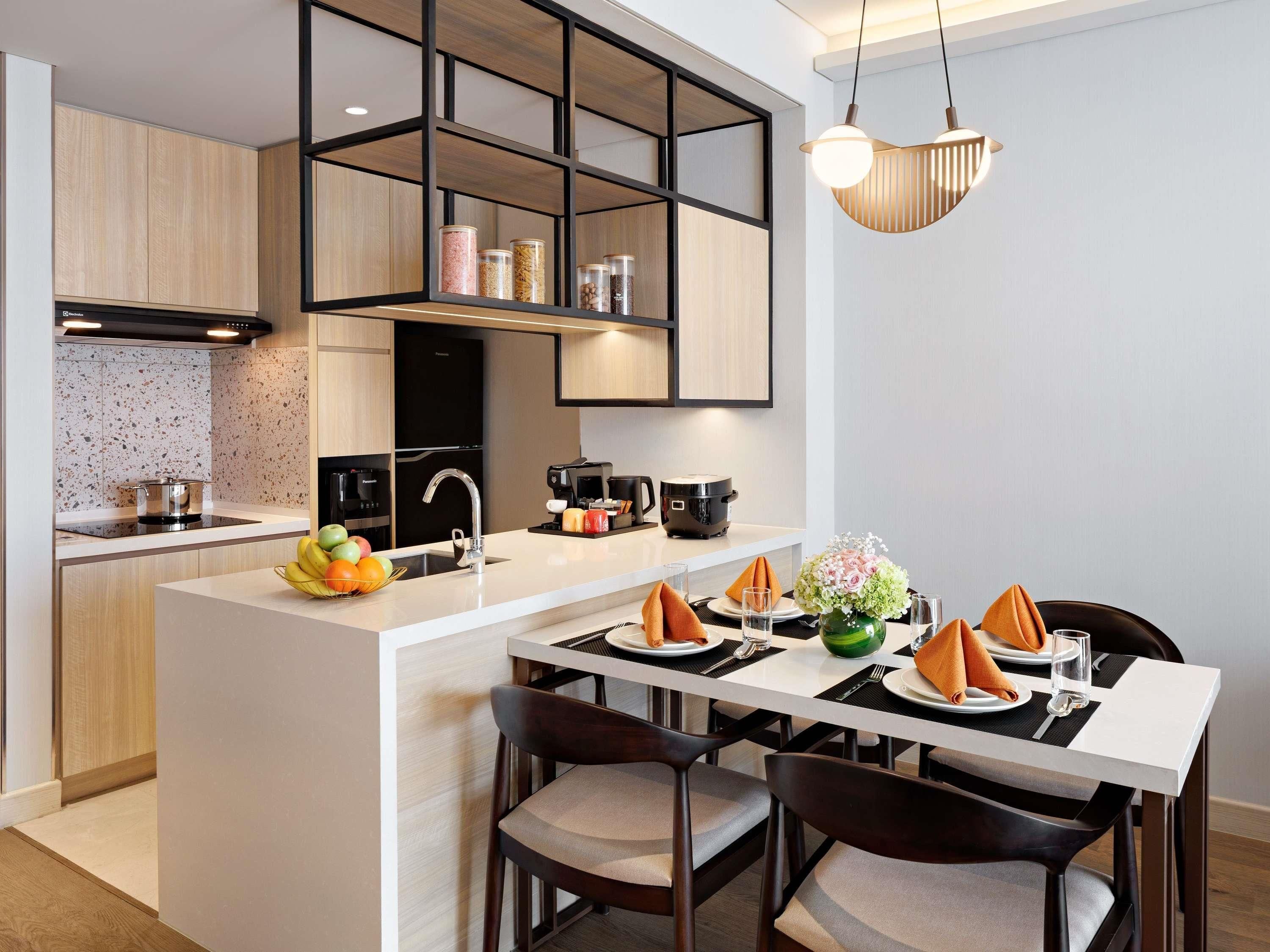 A modern kitchen with a central island, built-in appliances, and a dining area with a table set for two.