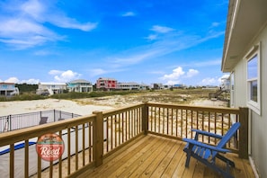 A wooden deck with a view of a beach and houses. - Updated, budget friendly 4br/2ba beach home. Steps to the beach- gorgeous views. (Gulf Shores)