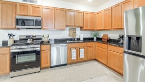 A modern kitchen with wooden cabinets, stainless steel appliances, and a granite countertop. - 1 Mi to Dtwn Flagstaff: Condo w/ 2 Balconies! (Flagstaff)