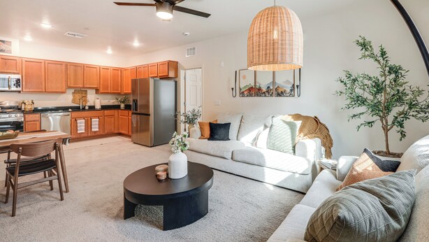 A modern kitchen with wooden cabinets, a refrigerator, and a dining area with a table and chairs. - 1 Mi to Dtwn Flagstaff: Condo w/ 2 Balconies! (Flagstaff)