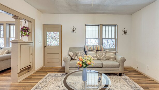 A living room with a sofa, a coffee table, and a door with a window. - Mountain Views: Peaceful Aguilar Getaway! (Aguilar)