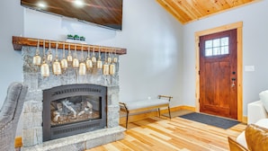 A stone fireplace with hanging bells, a bench, and a wooden door. - 6 Mi to Lake Winnipesaukee: New Hampshire Home (Gilford)