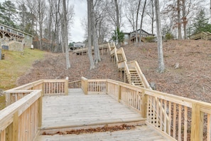 A wooden deck leading to a staircase with a view of houses in the background.