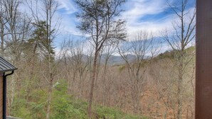 A balcony with a view of a forested area and mountains in the distance. - Ellijay Mtn Cabin w/ Hot Tub & Community Perks (Ellijay)