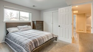 Ein Schlafzimmer mit Bett, Kommode und Kleiderschrank.