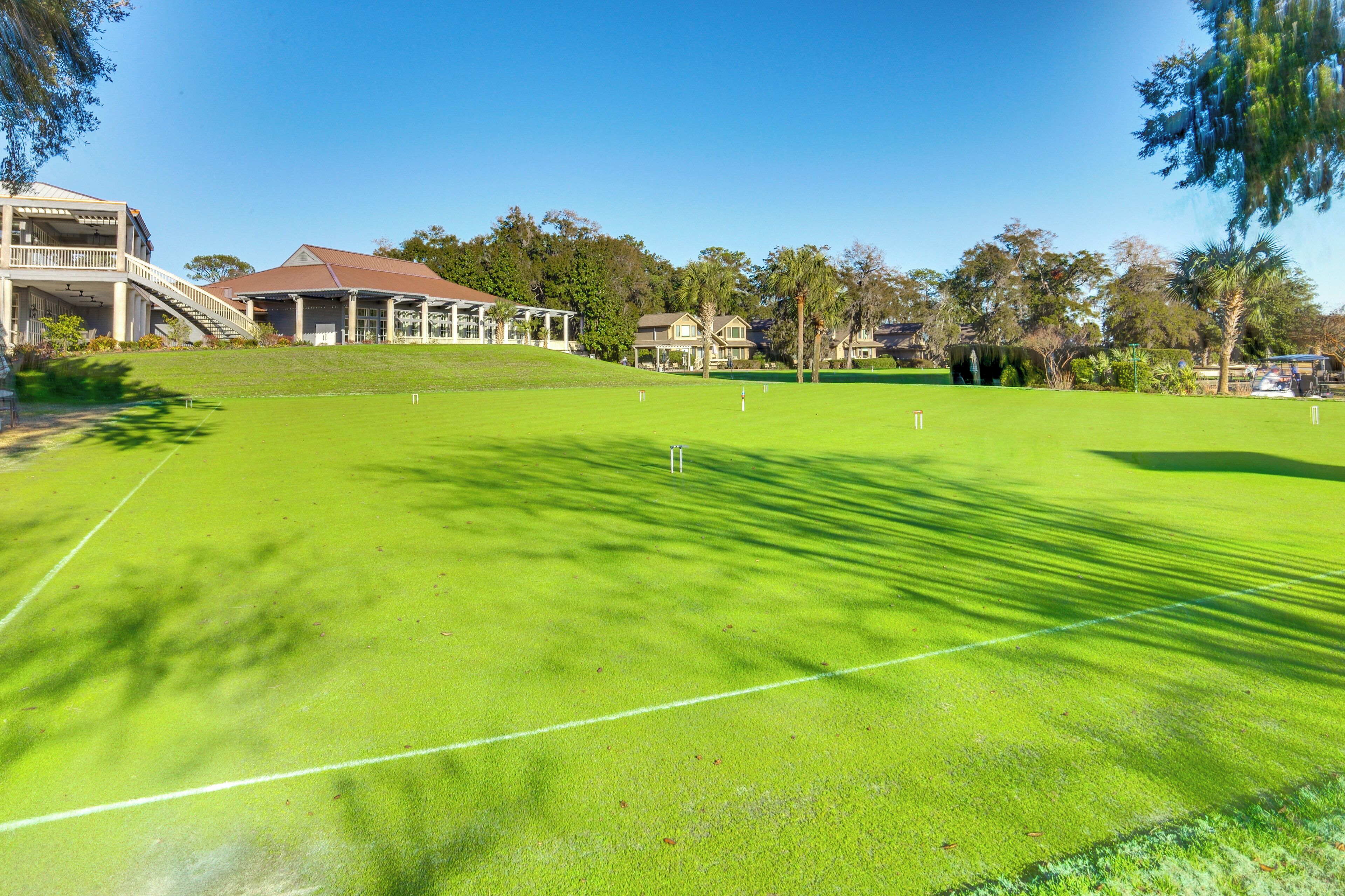 Un parcours de golf avec un terrain verdoyant bien entretenu, un club-house doté d’un espace de repos couvert et un immeuble résidentiel en arrière-plan.