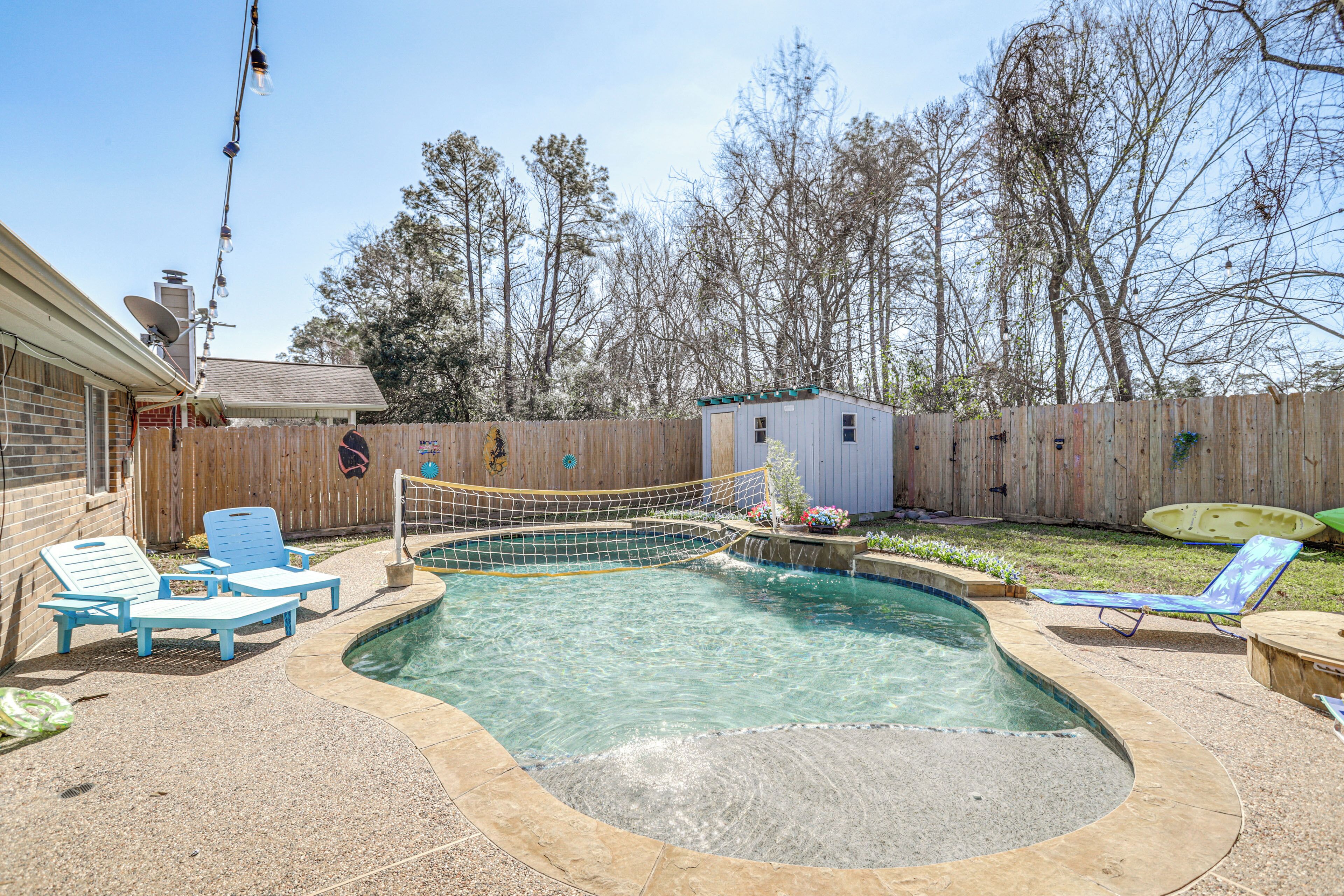 Ein Garten mit Schwimmbecken, Holzzaun und kleiner Gartenhütte.