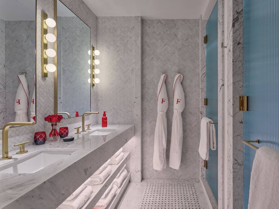 Een moderne badkamer met een grote spiegel, wastafel en douche.