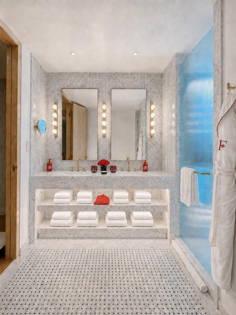 A bathroom with a large mirror, two sinks, and a towel rack.