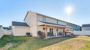 Une maison à deux étages dotée d’un patio couvert et d’un garage.
