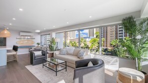 Un salon moderne comprenant un canapé, des fauteuils, une table basse et un coin repas.