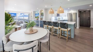 Une cuisine moderne dotée d’un îlot central, de luminaires suspendus et offrant une vue sur la ville.