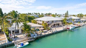 Une propriété située sur la côte, dotée d’un quai, d’un bateau et d’une grande maison avec un patio couvert.