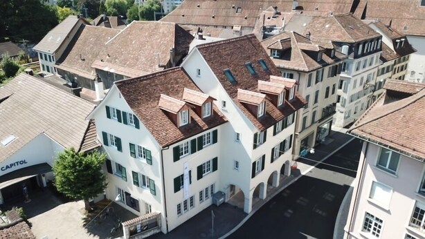 An aerial view of a historic building with multiple stories, prominent gabled roofs, and a central courtyard. - Business Apartment Solothurn (Solothurn)