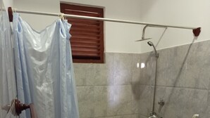 Un bagno con doccia, un WC e una tenda.