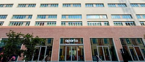 Un immeuble à plusieurs étages, doté d’une façade sobre, de grandes fenêtres et d’une devanture portant l’inscription « aparto ».