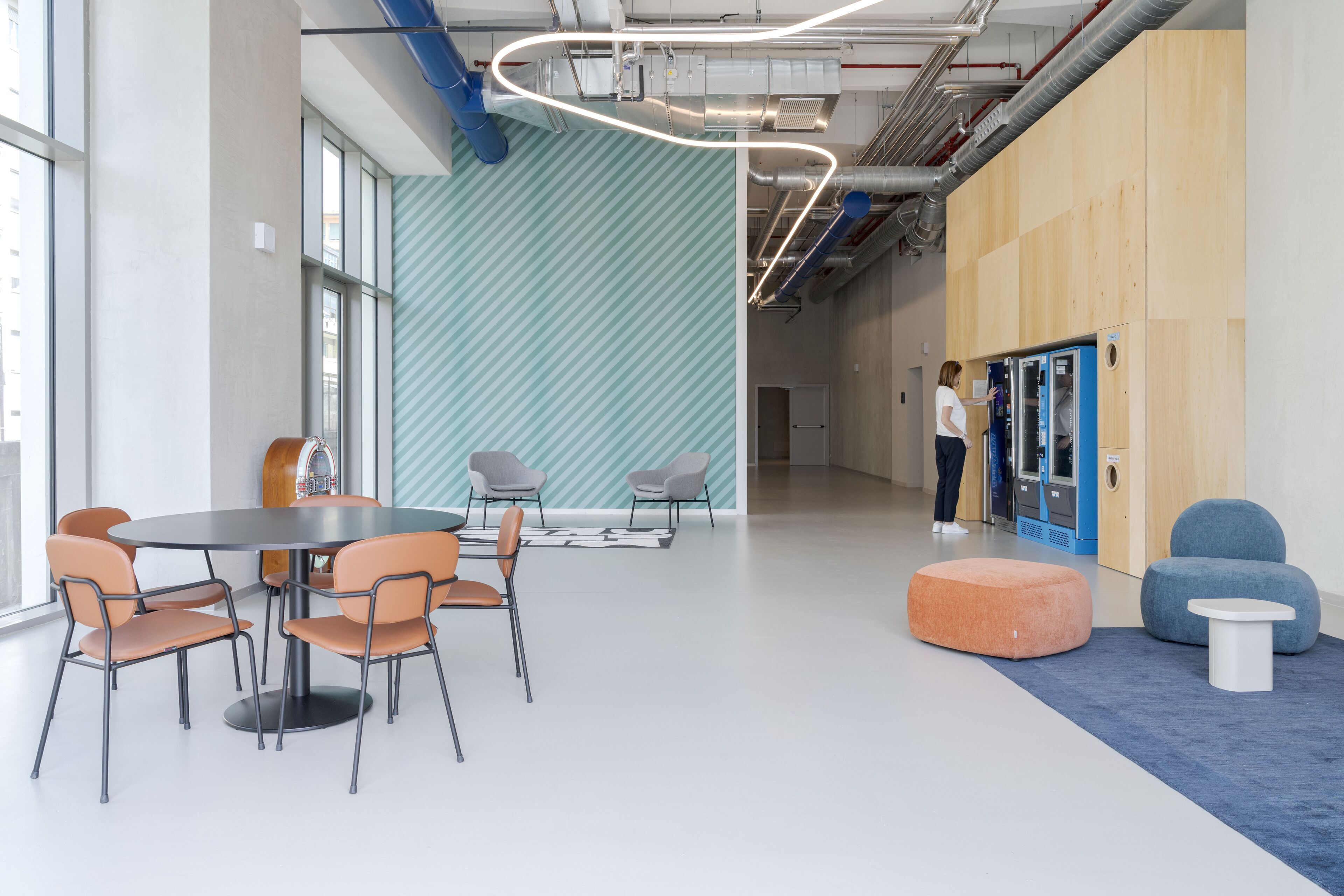 A modern interior with a round table and chairs, a blue and white patterned wall, and a blue and white carpet.