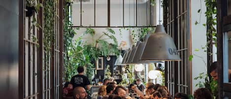 A restaurant with a long communal table, surrounded by patrons.