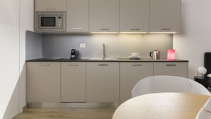 A modern kitchen with a microwave, sink, and a coffee maker.