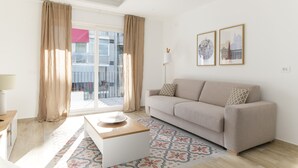 Ein modernes Wohnzimmer mit einer Couch, einem Couchtisch und einem gemusterten Teppich.