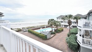 A beachfront property with a swimming pool, palm trees, and a view of the beach. - Oceanfront 3 BR Condo with Shared Pool! Admiral's Quarters II 13 (Surfside Beach)