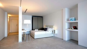 Un dormitorio moderno con cama, mesitas de noche, escritorio y armario.