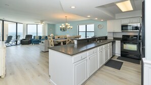 A spacious kitchen with a large island, white cabinetry, and a view to the outside. - Oceanfront 3 BR Condo with a Shared Pool! Surf Master 807 (Garden City)