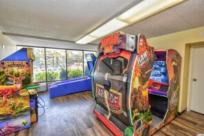 Un espace de jeux d’intérieur comprenant diverses bornes d’arcade, dont une inspirée du film « Jurassic Park ».
