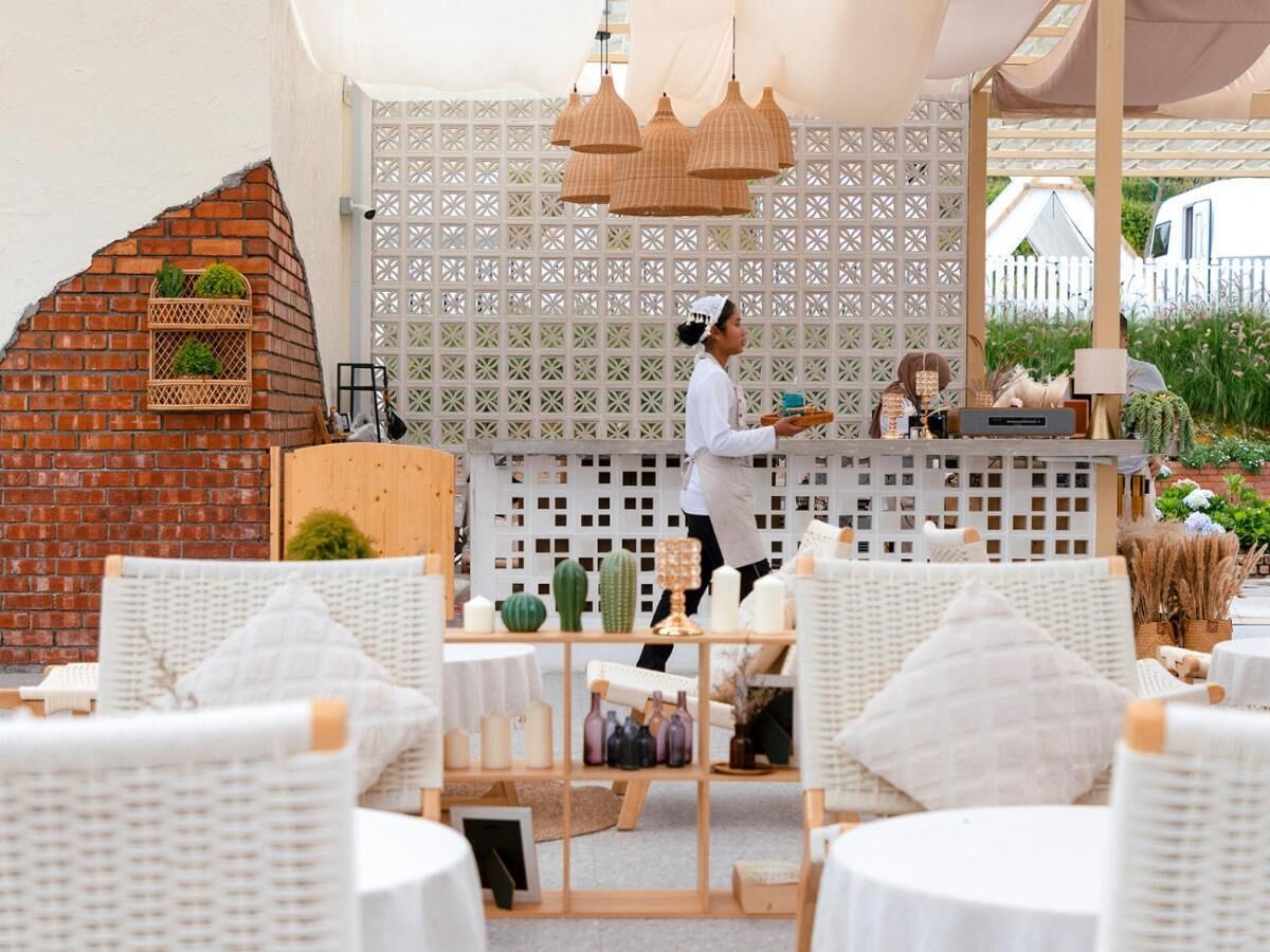 A cozy outdoor seating area with wicker furniture and a brick wall.