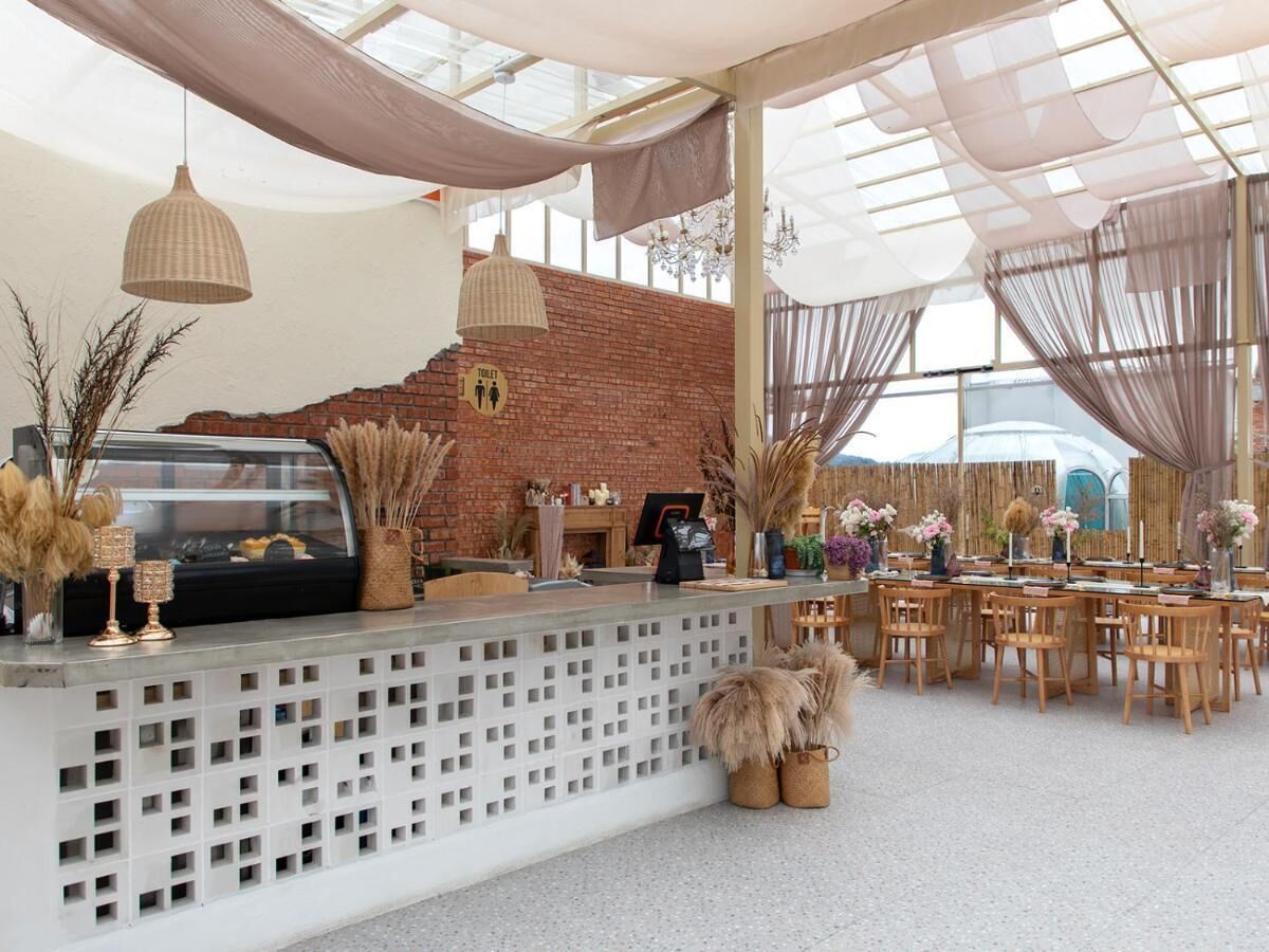 A reception area with a brick wall, a reception desk, and a seating area with tables and chairs.
