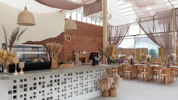 A reception area with a brick wall, a reception desk, and a seating area with tables and chairs.