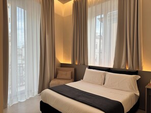 Habitació triple Deluxe, vistes a la ciutat | Caixa forta a l'habitació i escriptori 